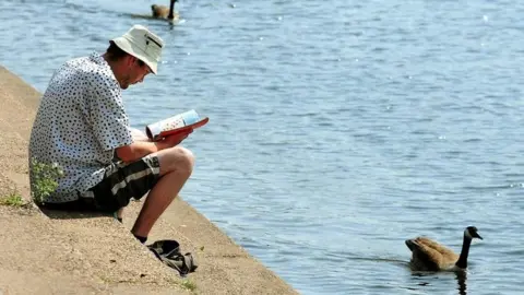 PA Man reading by River Trent