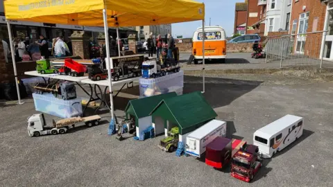 Rob Coombes A display of small scale trucks covered by a yellow marquee