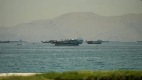 Boats in the Strait of Hormuz, seen from Oman, with mountains behind