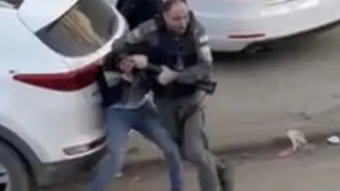 Huwara resident Still from video showing policeman and Ammar Mefleh struggle