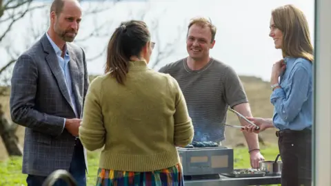 PA Media William and Kate chatting to croft owner Jeanette Lynn and her husband Jack Shaw while doing some outdoor cooking