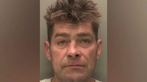 Lincolnshire Police A mugshot of Rolandas Karbauskas, a 49-year-old man with medium length brown hair and a slightly crooked nose