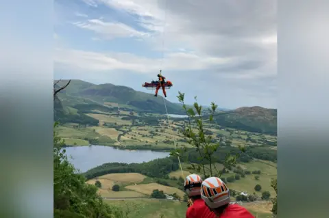 Kewswick Mountain Rescue Team The casualty being winched to a helicopter on a stretcher