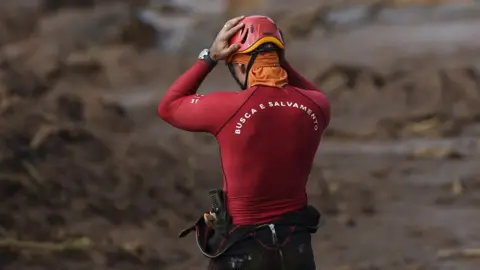 AFP A rescuer holds his head in his hands