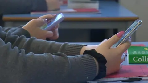 BBC Pupils holding mobiles