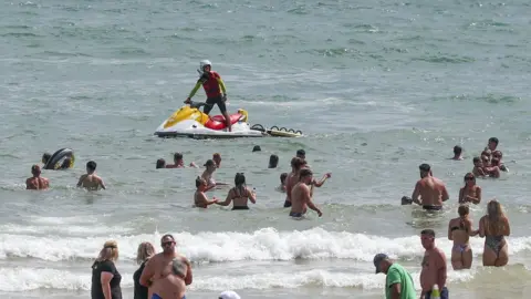 PA Media People enjoy the warm weather on Bournemouth beach. Met Office said Friday is the third hottest UK day on record as temperatures reached 37.8C at Heathrow Airport.