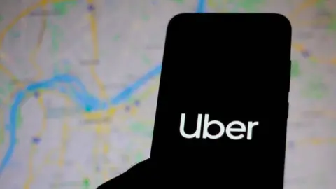 Getty Images silhouette of phone with Uber logo, map background