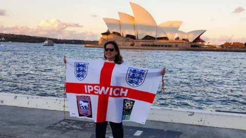 Ian Wallis An Ipswich supporter holding a flag in front of the Sydney Opera House