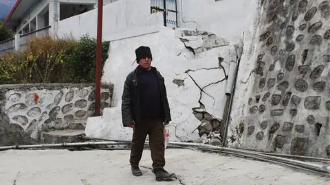 Getty Images A resident walks past a house damaged with cracks in Joshimath, in Chamoli district of Uttarakhand on 11 January 2023