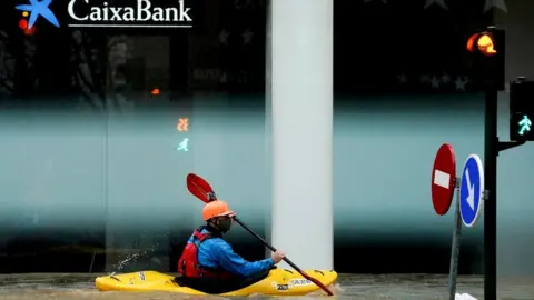 A man rides a kayak on a flooded road, following heavy rainfall in Pamplona, Spain, December 10, 2021