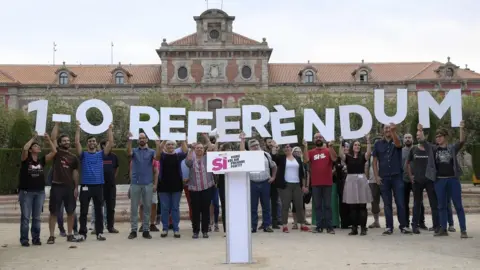 AFP Members of the Catalan pro-independence movement hold a placard alluding to the referendum vote on 1 October