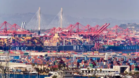 Getty Images Thousands of containers waiting to be loaded on trucks and trains, as large container ships are unloaded from the Ports of Los Angeles and Long Beach, while dozens of large container ships wait to be unloaded offshore Wednesday, Oct. 13, 2021