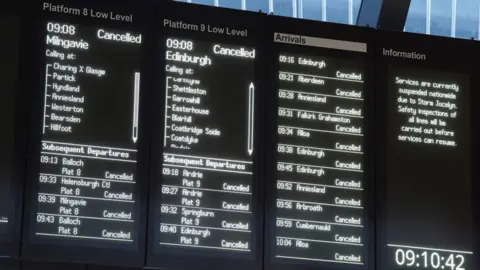 PA Media Information boards at Glasgow Queen Street showing all trains cancelled