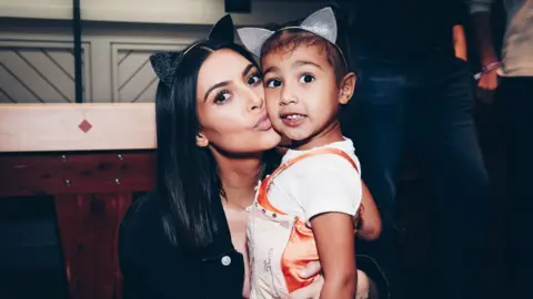 Forum photos via Getty Images Kim Kardashian and daughter, North West posing at Ariana Grande event in 2017 in matching cat ears