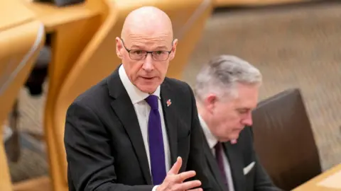 PA Media Deputy First Minister John Swinney delivers a budget statement to the Scottish Parliament at Holyrood, Edinburgh
