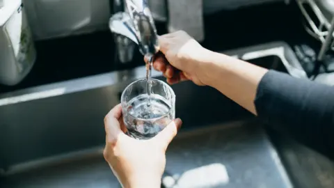 Glass being filled with water from a tap