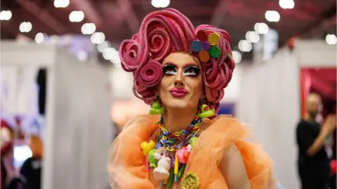 EPA A performer with extravagant pink hair and bright makeup