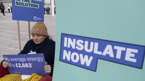 Mike Kemp/Getty Images Friends of the Earth insulate now protesters outside the ICC. Holding sign that reads insulate now