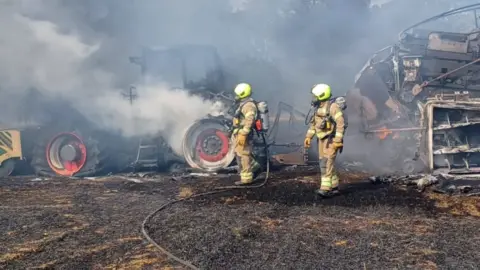 Firefighters and a tractor on fire