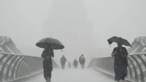 PA Media People walking in the rain on Millennium Bridge