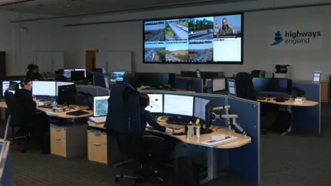 Oli Constable/BBC The National Highways control room with CCTV images on screens