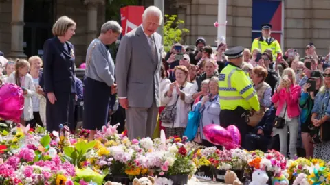 PA Media King Charles III visits Southport to look at flowers left in memory of the victims of the knife attacks