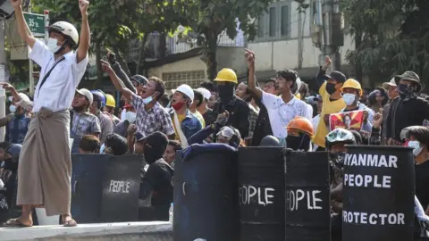 EPA Demonstrators shout slogans as they gather on the street during an anti-coup protest in Mandalay, Myanmar, 05 March 2021.