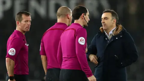 Swansea City manager Carlos Carvalhal speaks to the officials