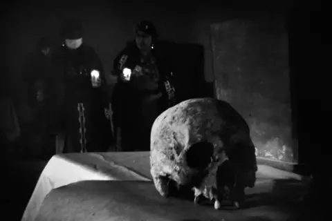 James Rodriguez Ixil Mayan locals women pray as forensic anthropologists carry out on-location forensic analysis of Catholic martyrs Jose Maria Gran Cirera, Domingo del Barrio Batz and Tomas Ramirez Caba in Chajul's Catholic church complex. Chajul, Quiche, Guatemala. February 11, 2021.