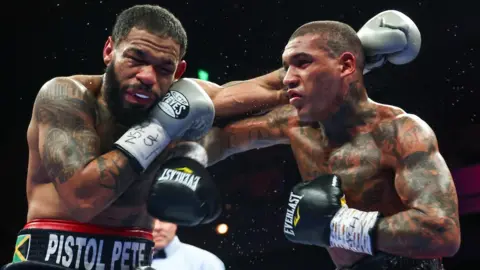 Peter Dobson and Conor Benn throwing punches