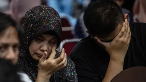 Getty Images Family of a victim of the Lion Air crash weep at a meeting with authorities