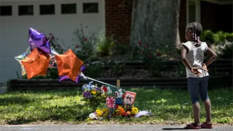 Getty Images A young girl looks at a memorial for Ahmaud Arbery near where he was shot and killed