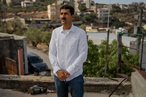 BBC Abed Wadi on his rooftop in Qusra. "We wanted hope for our children, but it has gone," he said.