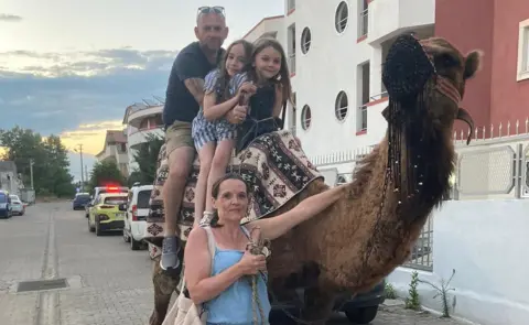 Daniel Metcalf Emma Baxter and Daniel Metcalf with their daughters with a camel on holiday in Turkey