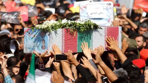 EPA Iranians carry the coffins of people killed in the attack on a military parade in Ahvaz (24 September 2018)