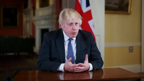 Getty Images Boris Johnson addresses the public on new booster target