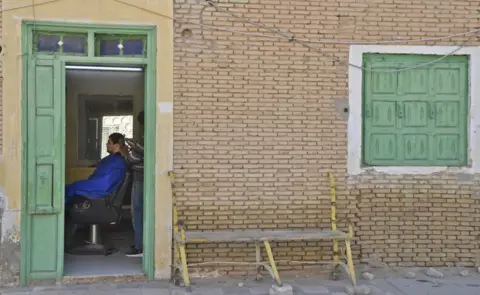 AFP A barber serves a costumer in Nefta, Tunisia - Sunday 13 February 2022