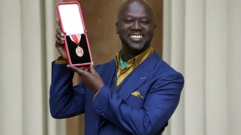 Getty Images Sir David Adyaje with his OBE