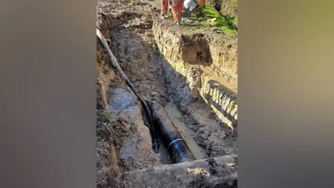 South East Water A pipe in a muddy hole