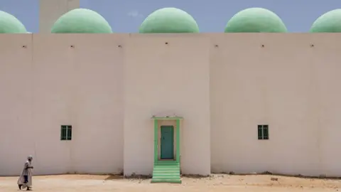 JOHN WESSELS/AFP A antheral   arrives astatine  the Grand Mosque for Friday prayers successful  Nouakchott connected  June 28, 2024. 