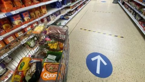 Getty Images Social distance markers in a supermarket