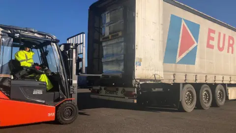 BBC Boxes of supplies being loaded into a truck