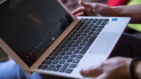 Getty Images a woman watches netflix on her laptop