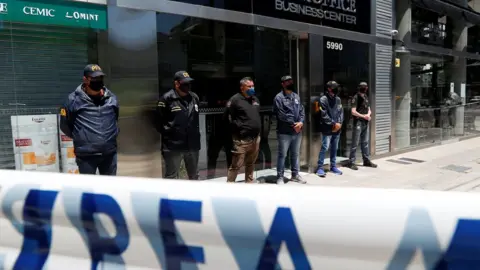 Reuters Police officers stand guard outside the building where Leopoldo Luque, the personal doctor of late Argentine soccer legend Diego Armando Maradona, has his office in Buenos Aires, Argentina November 29, 2020.