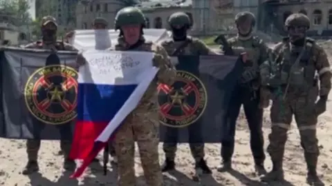 Telegram Yevgeny Prigozhin flanked by Wagner fighters