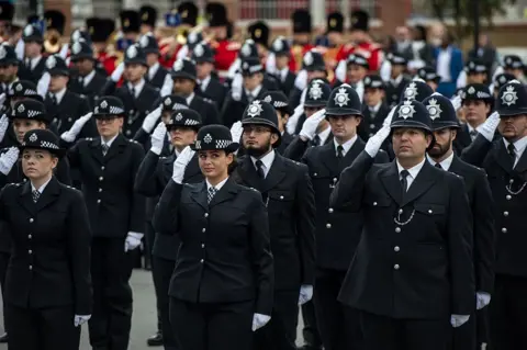 Getty Images New Metropolitan police recruits salute in London