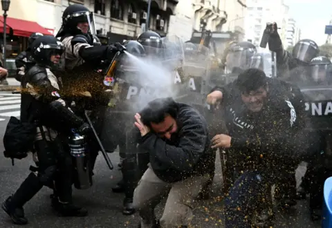 LUIS ROBAYO/AFP Riot police use pepper-spray on demonstrators during a protest outside the National Congress in Buenos Aires on September 11, 2024. 