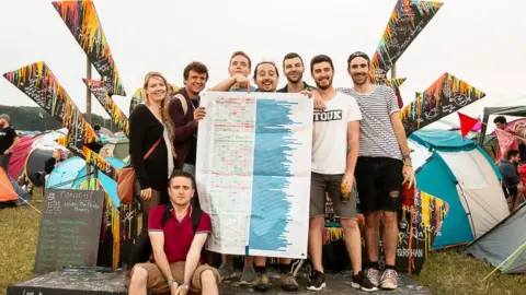 Dan Hess People hold a giant spreadsheet at a festival