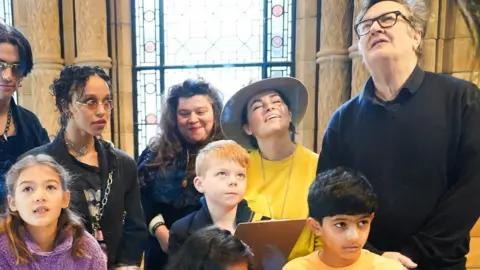 PA Media Artists as part of the Wild Escapes project look at a display at the Natural History Museum with a group of primary school children