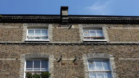 BBC General view of a blue sky and terraced housing